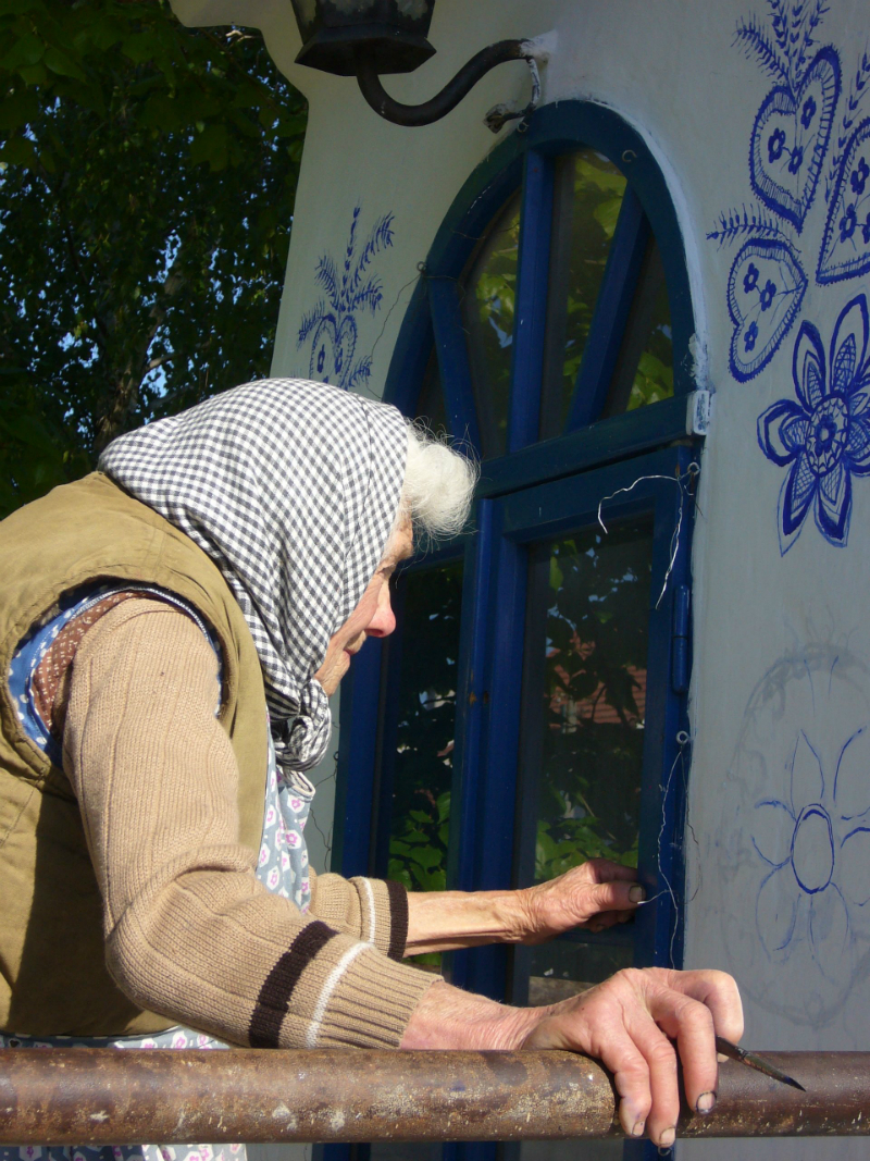 стара жена рисува на стената