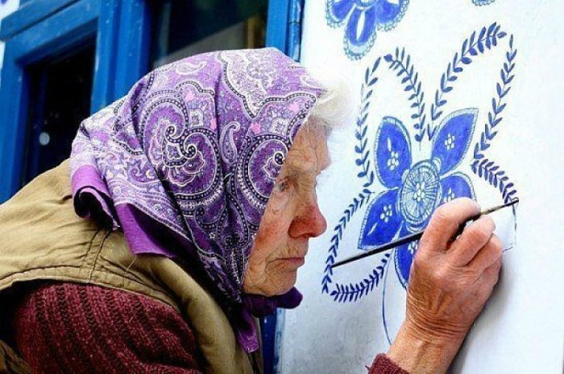 стара жена рисува на стената