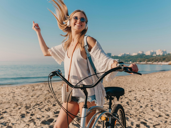 жена с колело на плажа