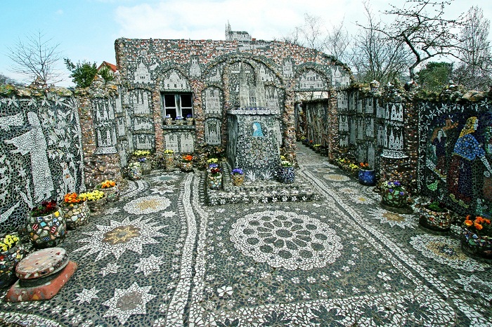 Къщата и целият двор са украсени с мозайки от парчета стъкло, порцелан и фаянс.